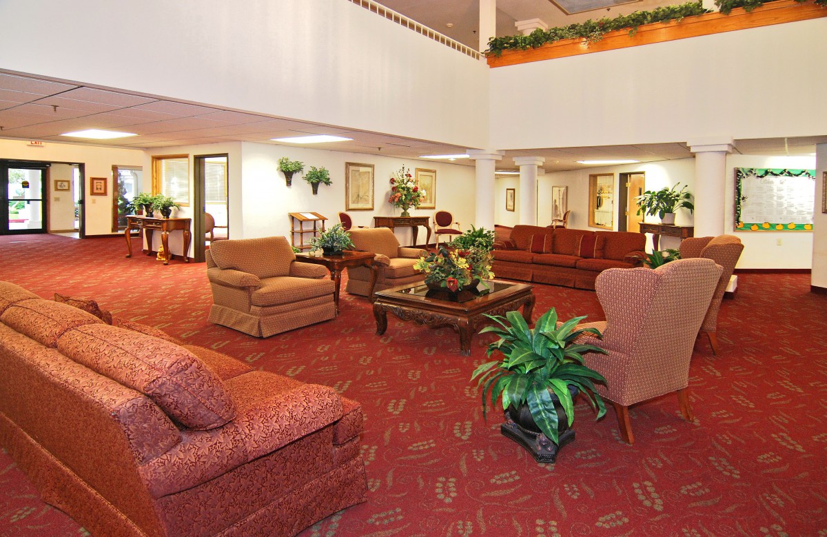 A spacious hotel lobby with comfortable seating and decorative plants.
