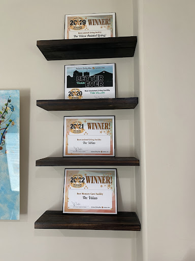 A collection of awards and certificates displayed on wooden shelves.
