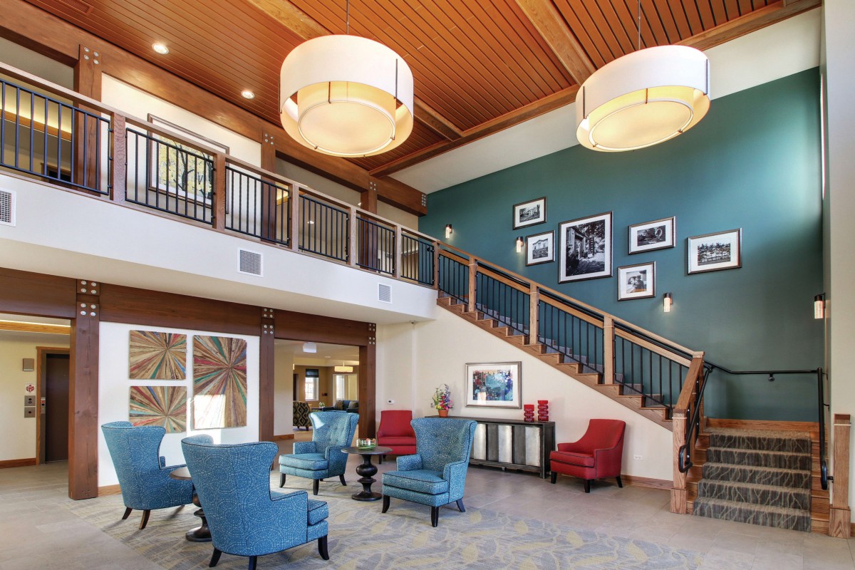 A modern lobby area featuring comfortable seating, elegant lighting, and a stylish staircase.
