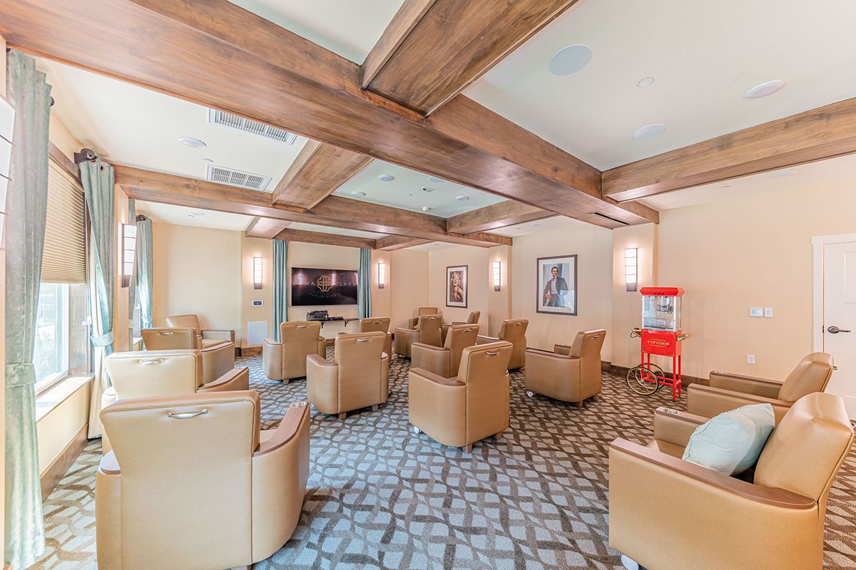 A cozy lounge area featuring comfortable chairs, a television, and a popcorn machine.
