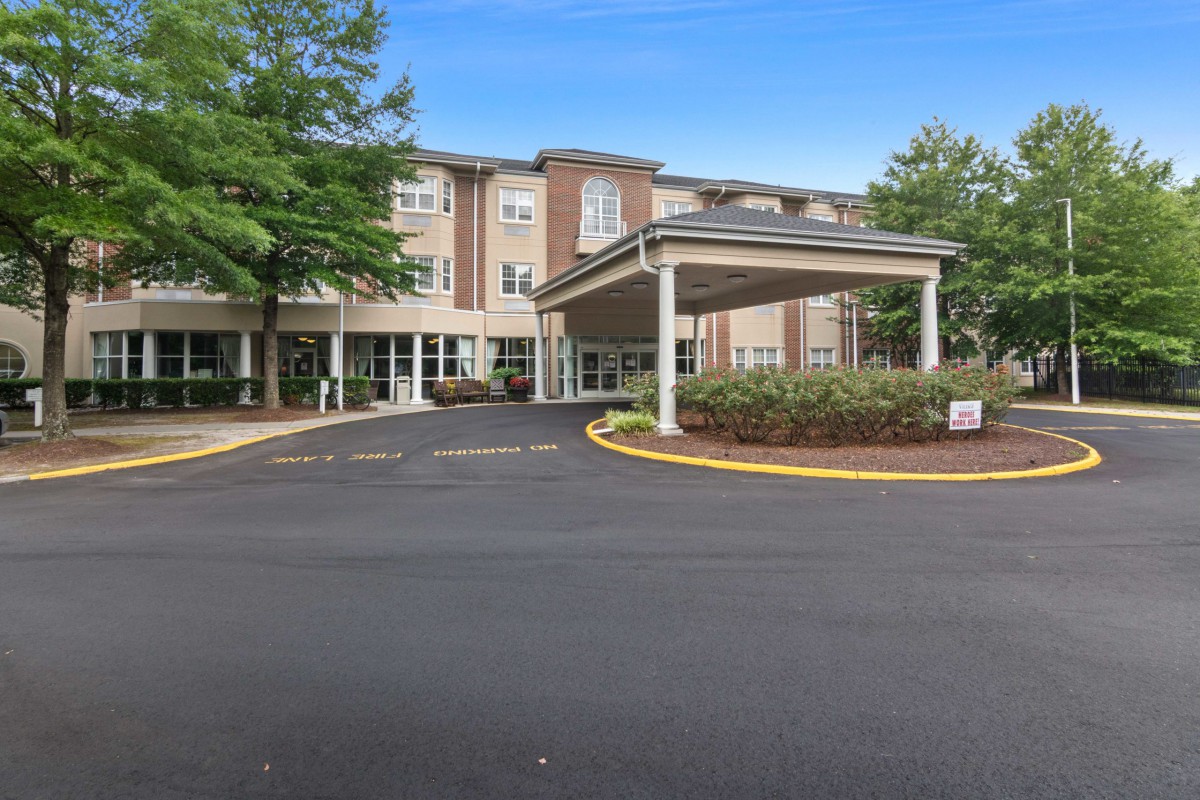 A hotel building with a covered entrance and surrounding trees.
