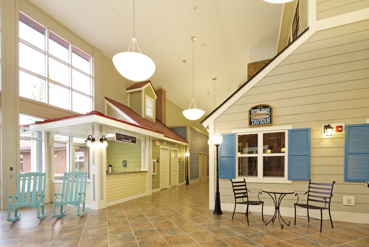 A spacious indoor hallway designed to resemble a village street with storefronts and bright lighting.