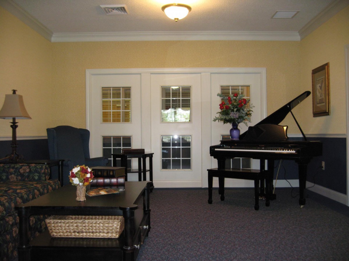 A cozy living room featuring a grand piano and elegant furniture.