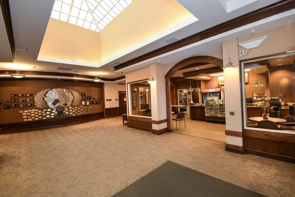 A spacious, well-lit lobby with a reception desk and seating area.