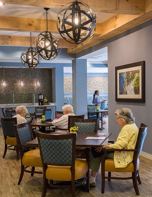 Seniors sitting in a dining area of a retirement home.
