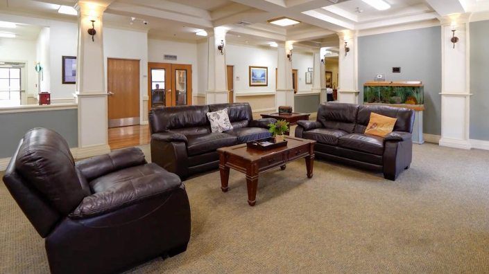 A cozy lobby seating area with leather sofas and a wooden coffee table.
