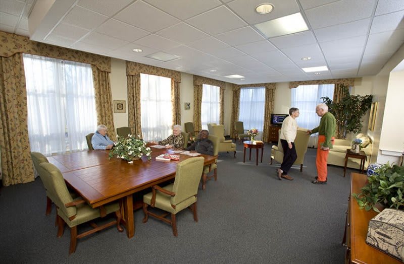 A communal living area in a senior home where residents are socializing and relaxing.