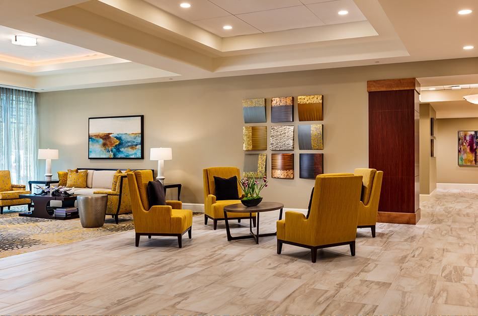 A modern lobby with stylish yellow chairs and contemporary artwork.