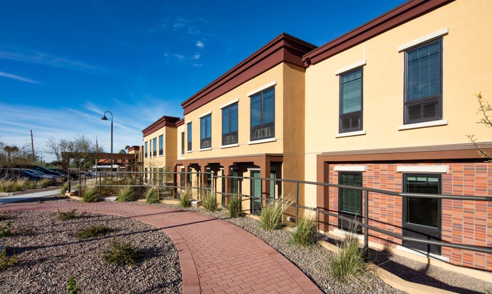 A row of modern townhouses with a well-maintained walkway and landscaped surroundings.