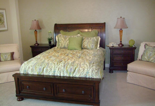 A well-decorated bedroom with a wooden bed and matching nightstands.
