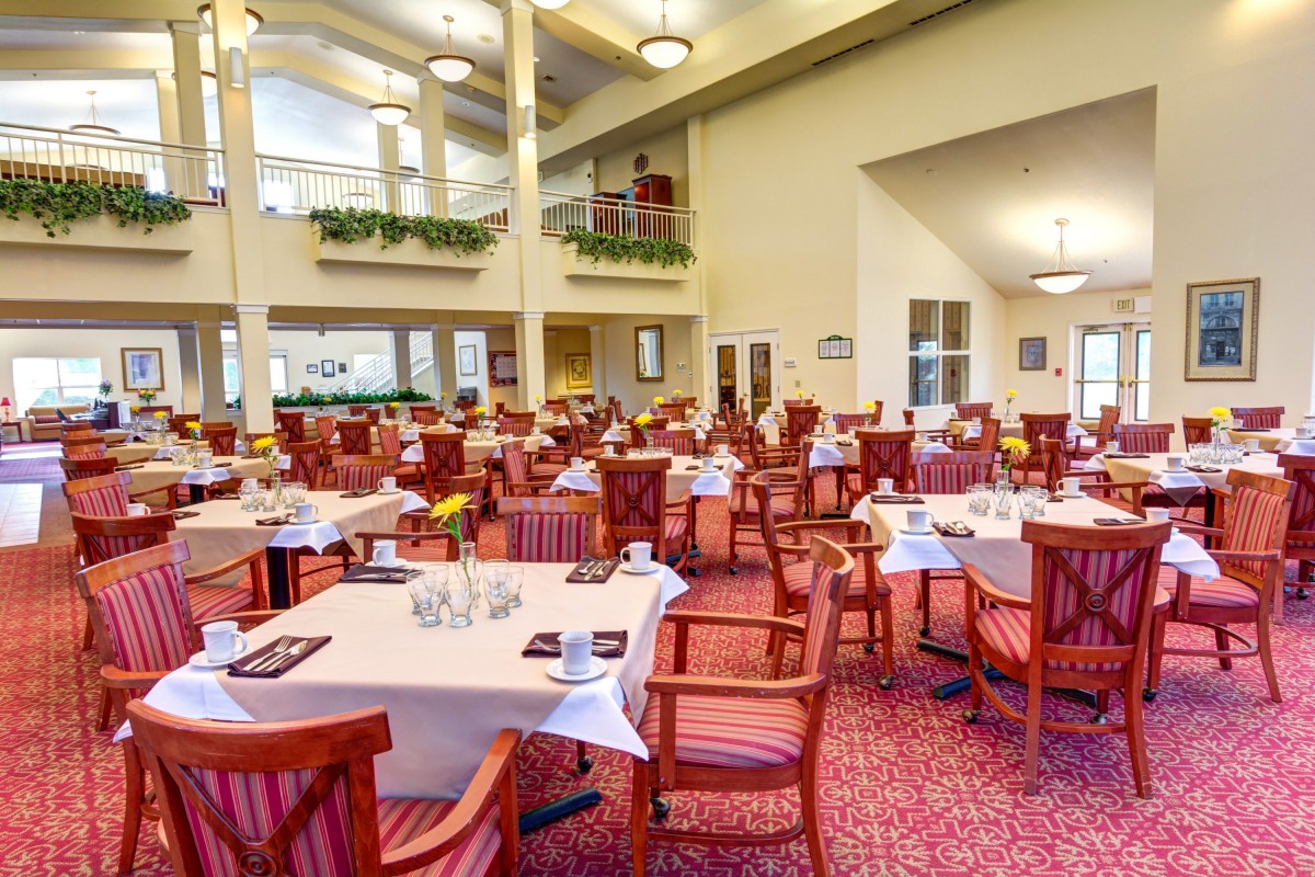 An elegant dining room with neatly arranged tables and chairs, featuring a warm and inviting ambiance.