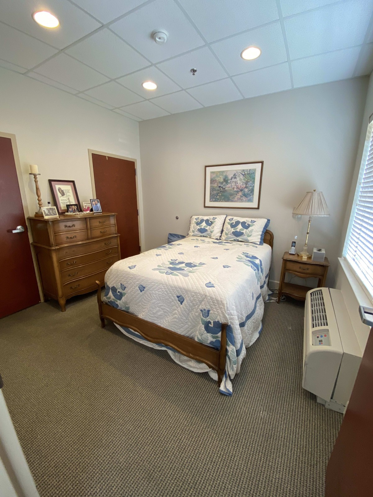 A cozy bedroom with a neatly made bed and wooden furniture.