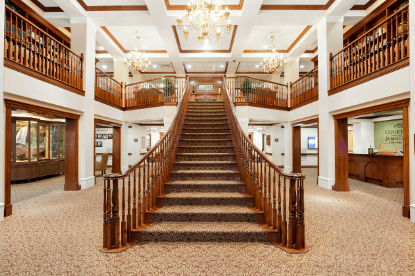A stunning grand staircase adorned with chandeliers in a luxurious interior setting.