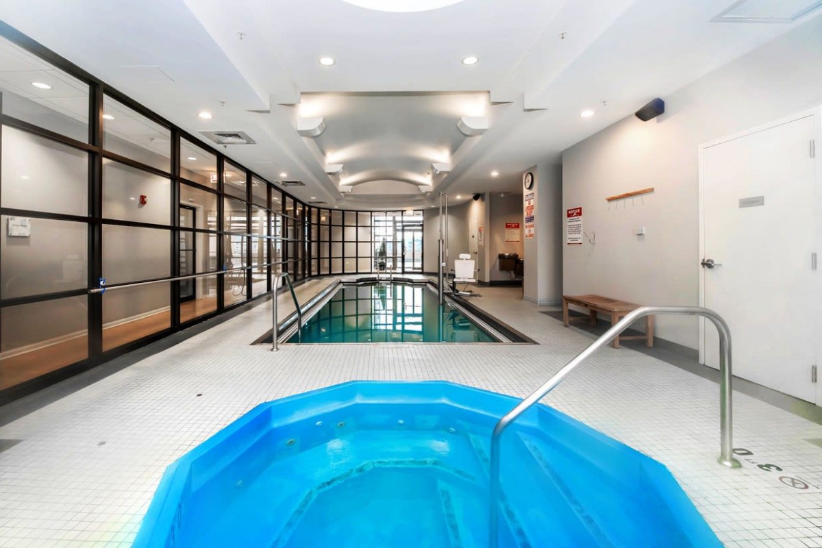 A modern indoor facility featuring a pool and hot tub, designed for relaxation and leisure.