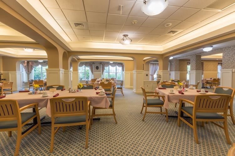 An empty dining room with neatly arranged tables and chairs.