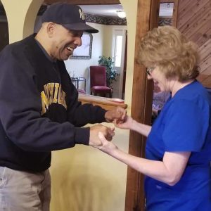 A joyful moment of interaction between a caregiver and a resident, showcasing community spirit and support.