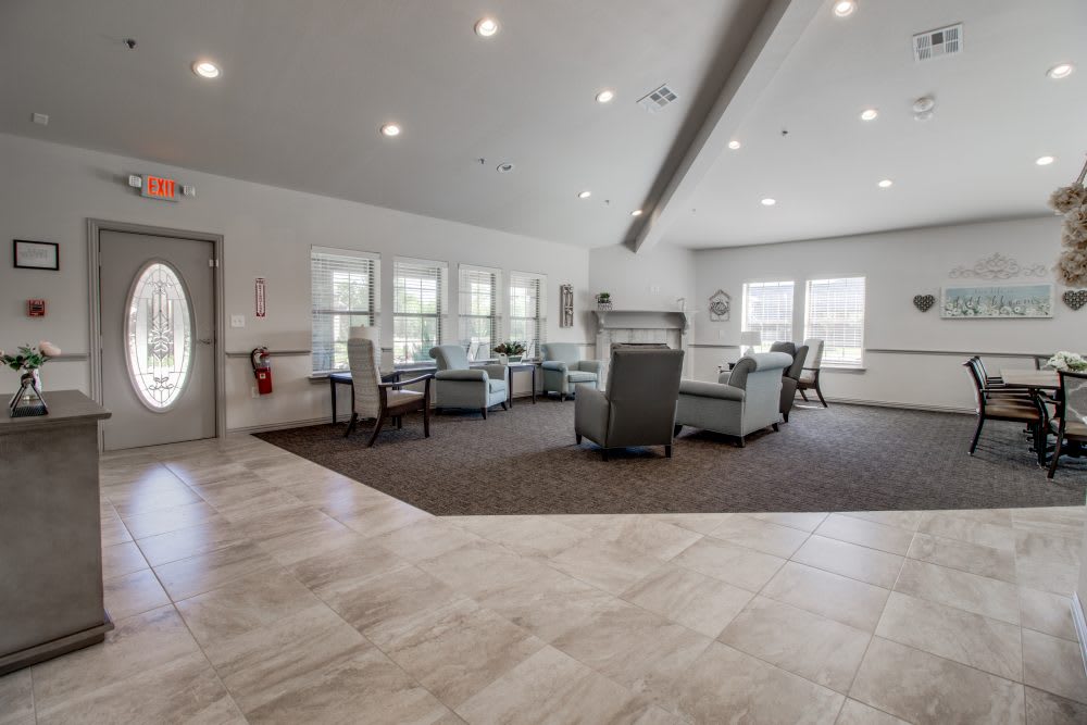 A spacious, well-lit living room with modern furniture and large windows.
