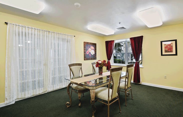 A well-lit dining room with elegant furniture and decorative artwork.