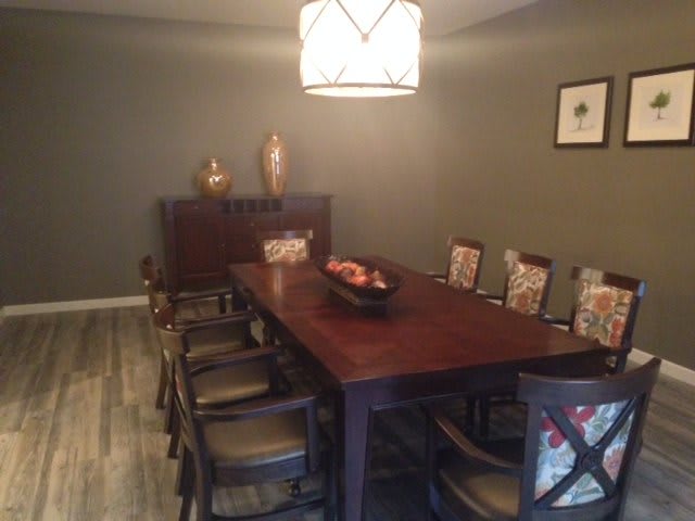 A cozy dining room with a wooden table, chairs, and warm lighting.
