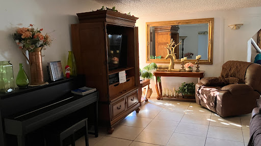 A cozy living room featuring a wooden cabinet, piano, and decorative elements.