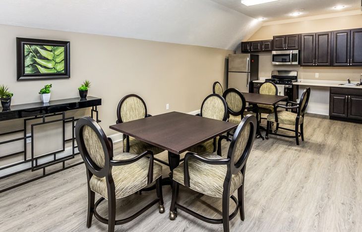 A modern dining area with a table and chairs, adjacent to a kitchen.