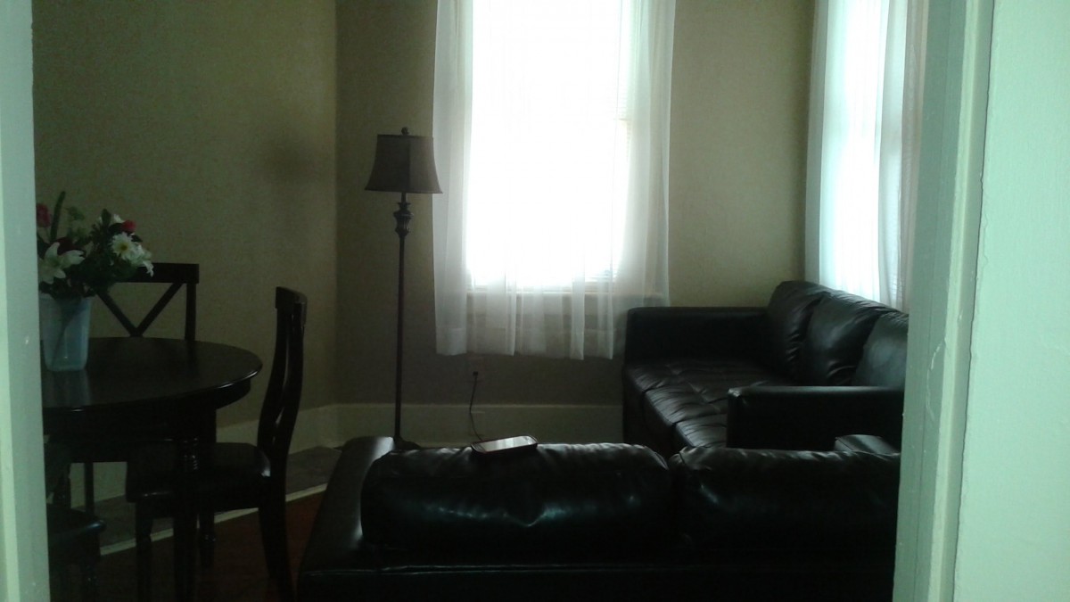 A minimalist living room with a sofa, lamp, and large window.