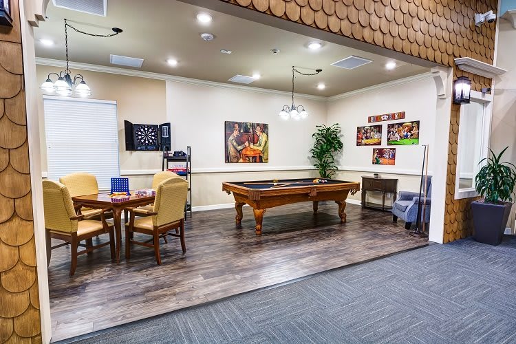 A cozy recreation room featuring a pool table and seating area with vibrant artwork on the walls.