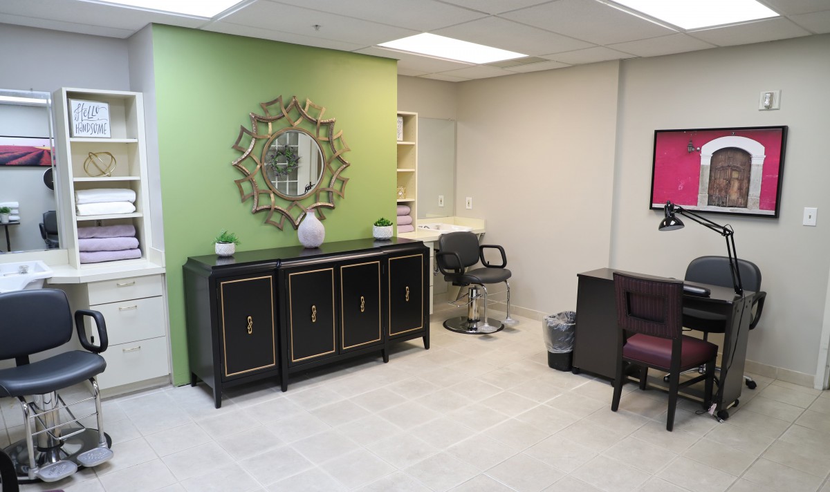 A modern office waiting area with stylish furniture and a green accent wall.