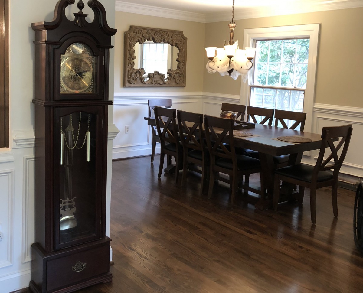 A traditional dining room featuring a grandfather clock and elegant furnishings.