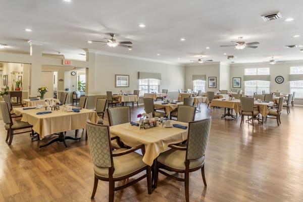 A spacious and elegantly decorated dining room with neatly arranged tables and chairs.