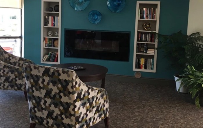 A cozy living room with a fireplace and bookshelves.