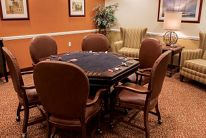 A cozy indoor game room featuring a poker table surrounded by comfortable chairs.