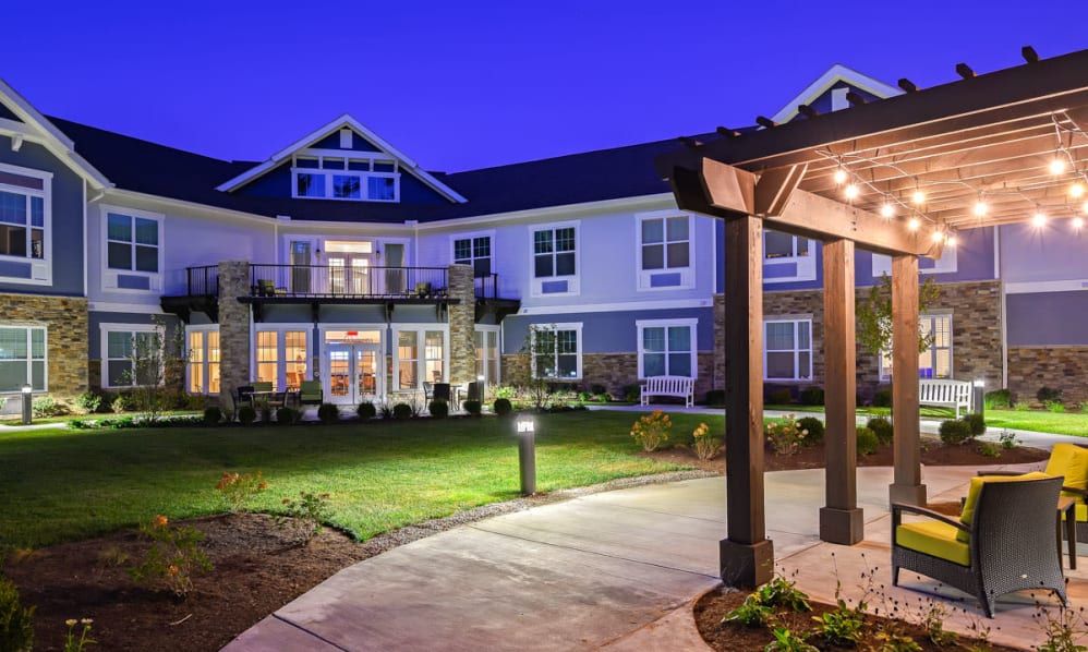 A well-lit building exterior with landscaped surroundings and a pathway at night.