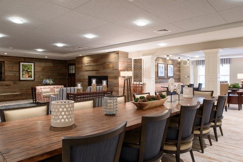 A modern dining area featuring a large wooden table, comfortable chairs, and stylish lighting.