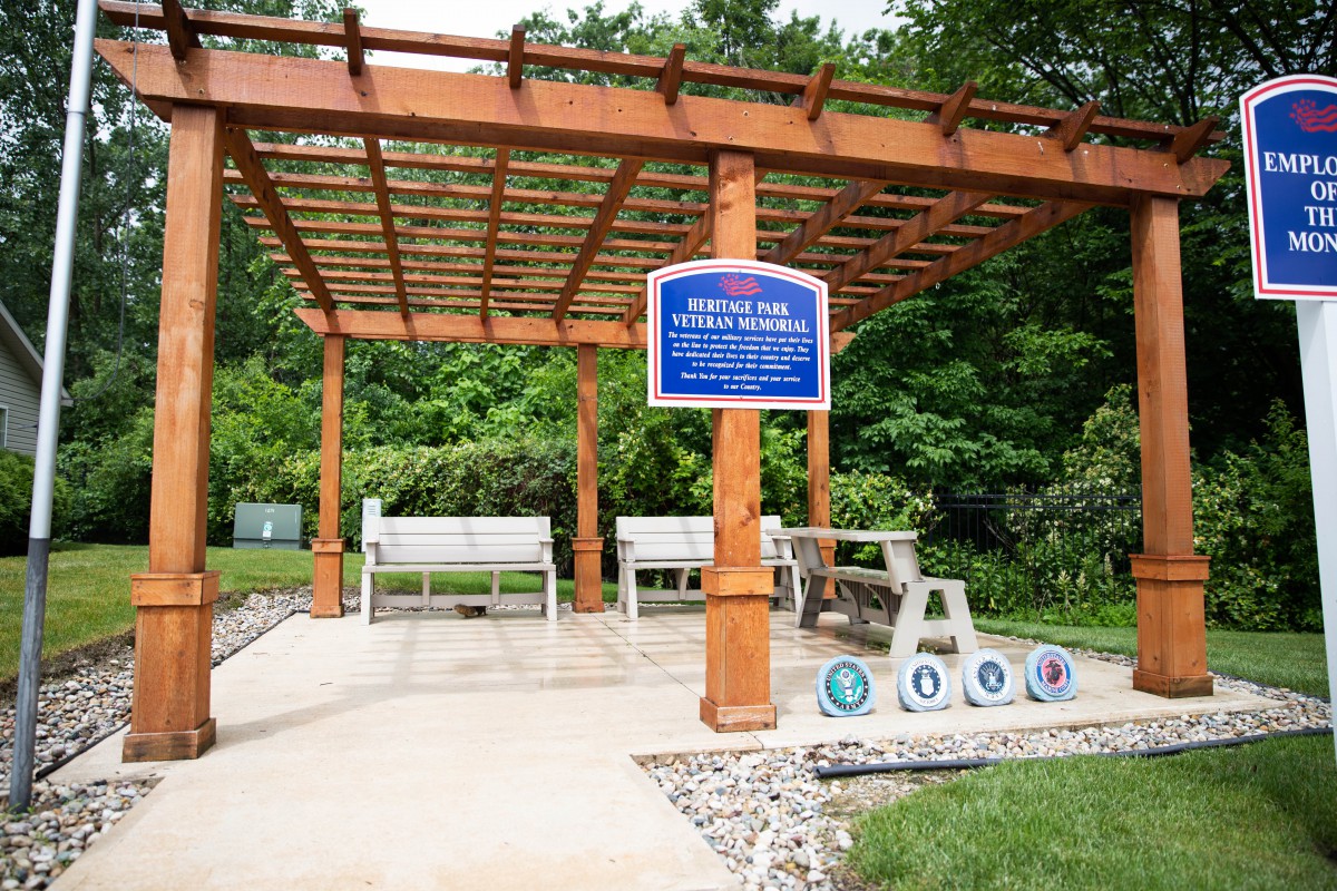 A memorial pergola with benches honoring veterans, set in a tranquil outdoor landscape.