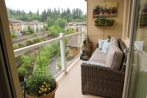 A cozy balcony adorned with plants and comfortable seating, offering a serene view of the lush landscape.