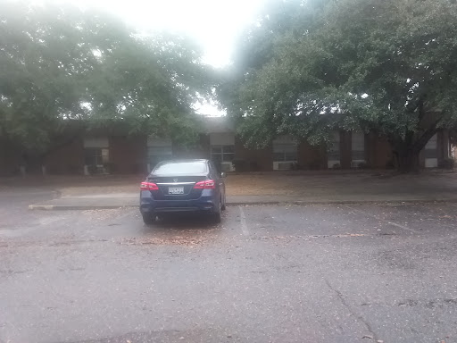 A parked car in a rainy urban setting, partially obscured by fog.