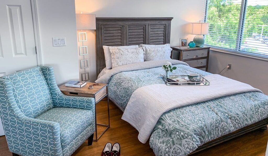 A cozy bedroom with stylish decor and a neatly made bed.