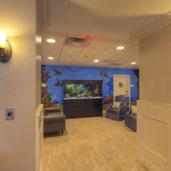 A cozy waiting room with an aquarium and comfortable seating area.