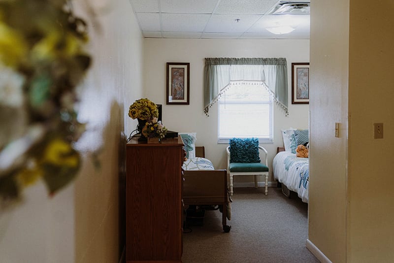 A cozy bedroom with two beds, a window, and simple decor.