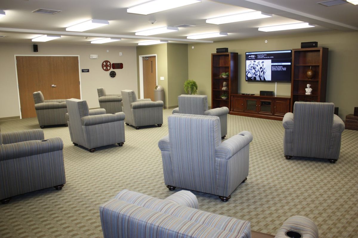 A modern living area with multiple chairs and a television.