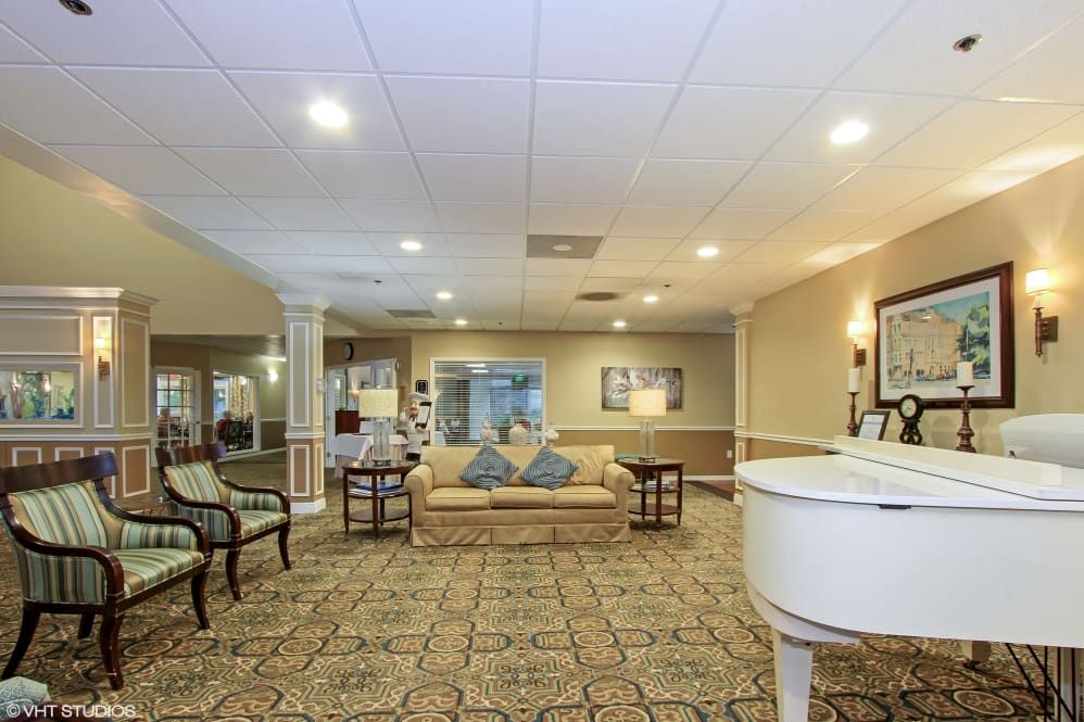 A cozy and elegantly furnished lobby with seating area and a piano.