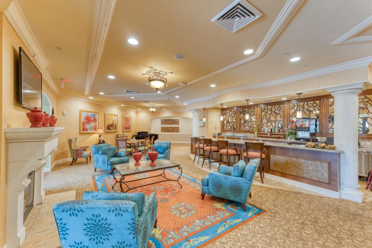 A spacious lobby with elegant furniture and a bar area.