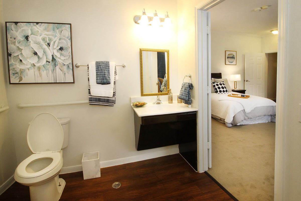 A modern bathroom with a view into an adjacent bedroom.
