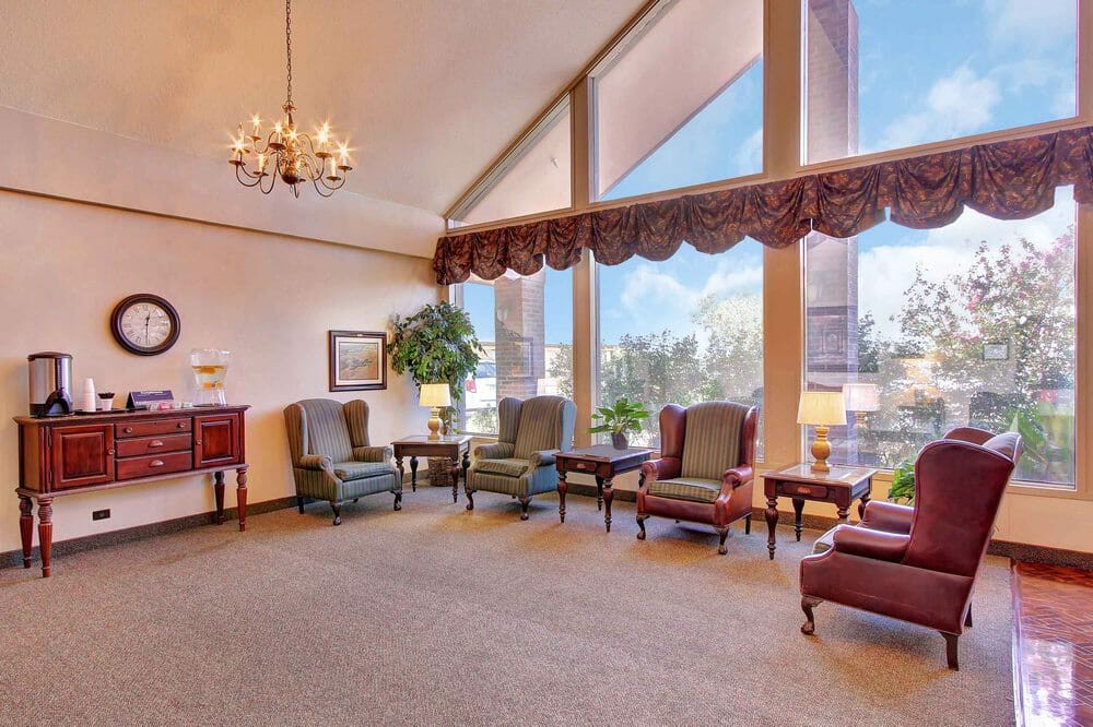 A spacious lounge area with elegant furniture and large windows.