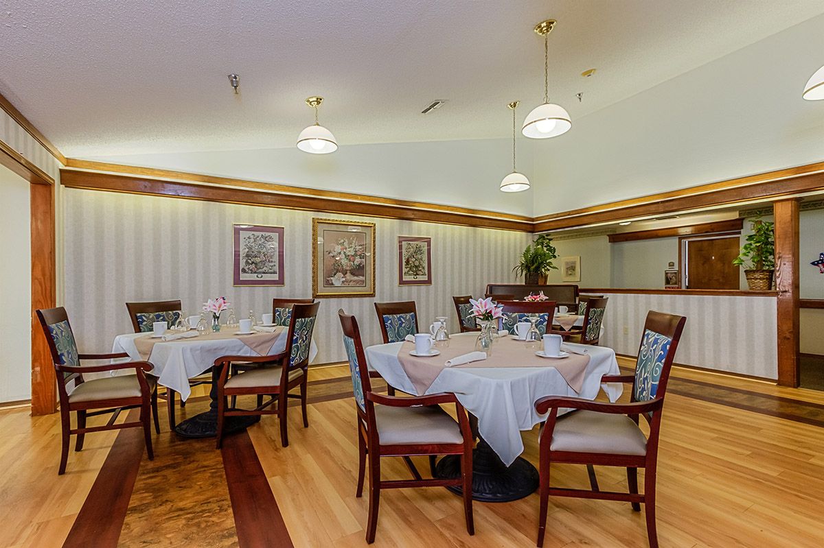 An elegantly furnished dining area with neatly set tables and decorative lighting.