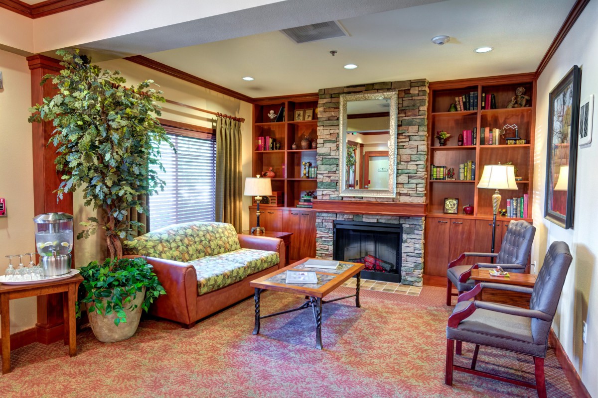 A cozy living room with a fireplace, sofa, and built-in bookshelves.