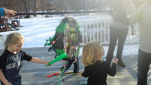 Kids enjoying a fun outdoor activity with a colorful piata on a snowy day.