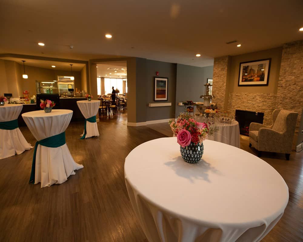 A cozy event space with elegantly decorated tables and floral arrangements.