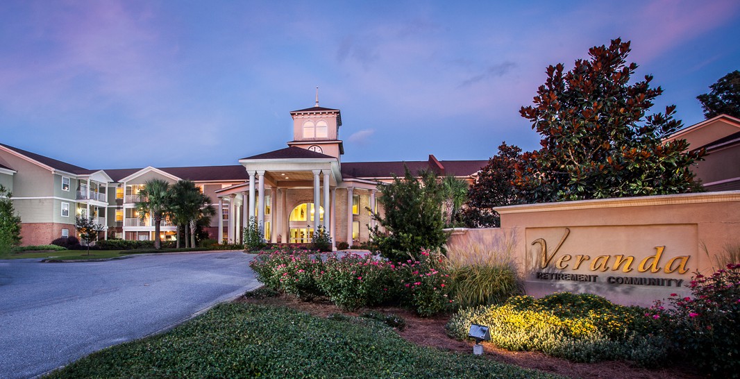 A beautifully lit resort entrance with columns and landscaped gardens at dusk.